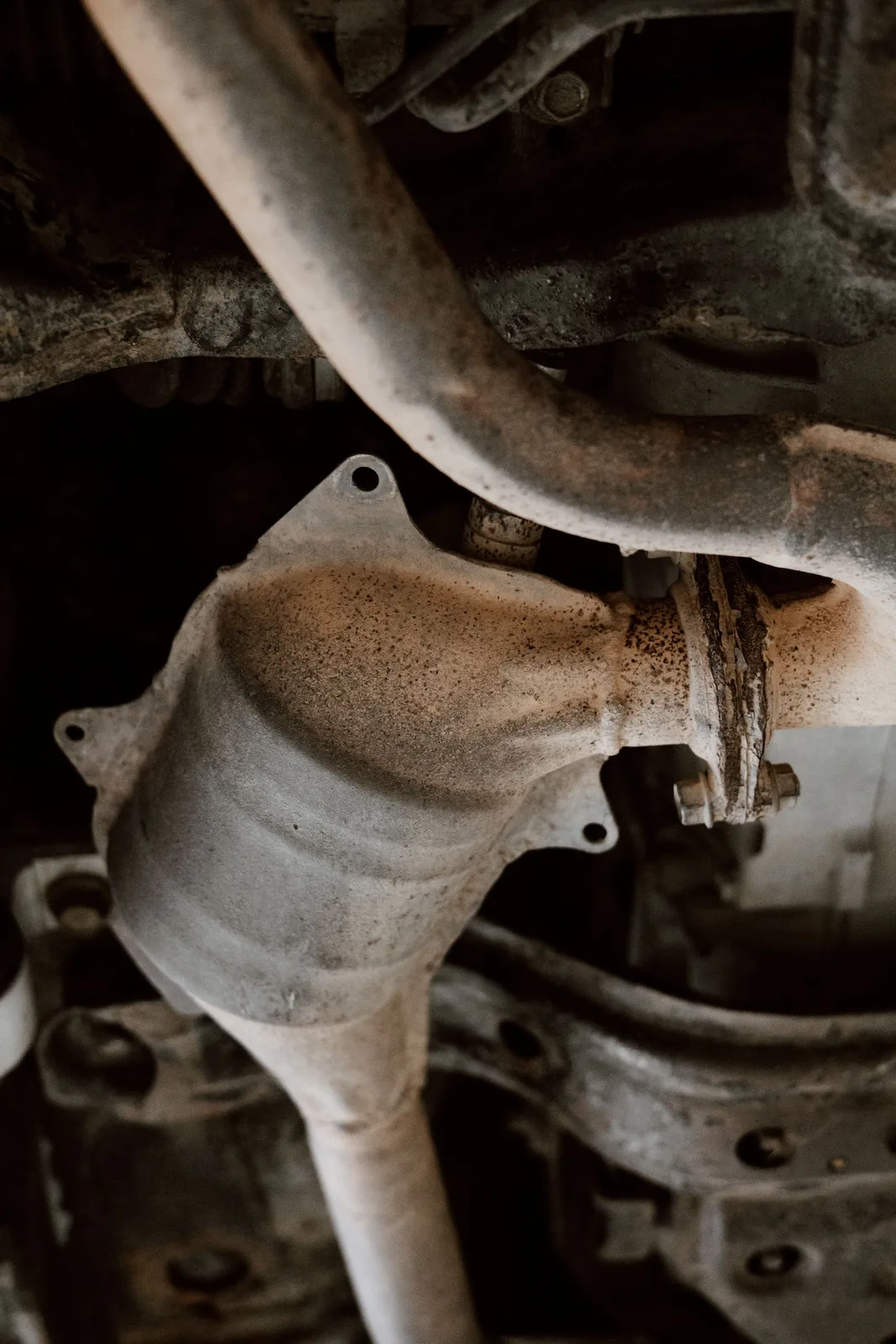 The exhaust after-treatment section seen from beneath a vehicle, heat-discoloured and soot-stained