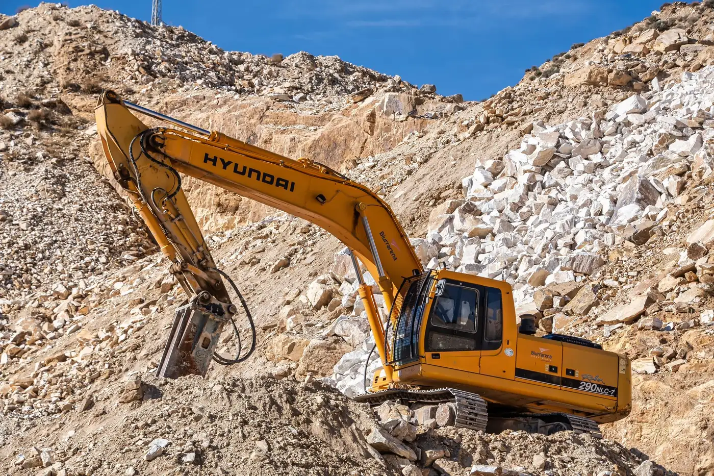 A tracked excavator working in a rock quarry
